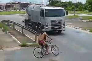 ciclista-colide-em-caminhao-ao-entrar-em-rotatoria,-cai-na-pista,-levanta-e-sai-pedalando