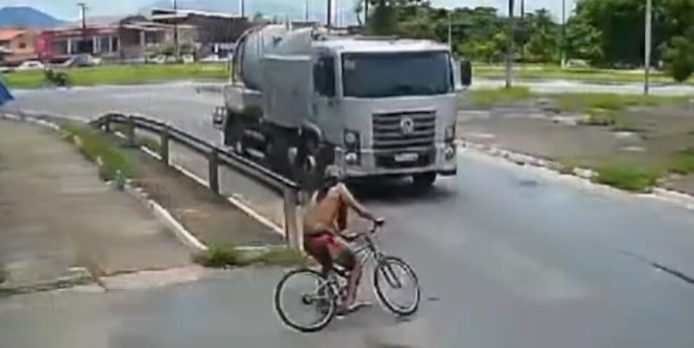 ciclista-colide-em-caminhao-ao-entrar-em-rotatoria,-cai-na-pista,-levanta-e-sai-pedalando