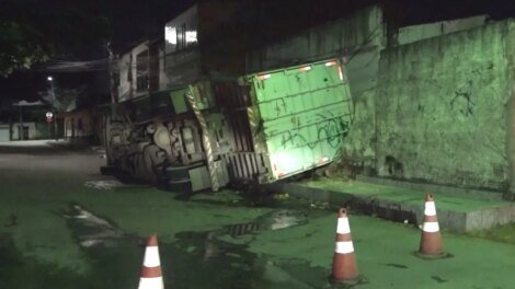 acidente:-caminhao-de-lixo-desvia-de-carro,-tomba-na-pista-e-derruba-muro-de-residencia
